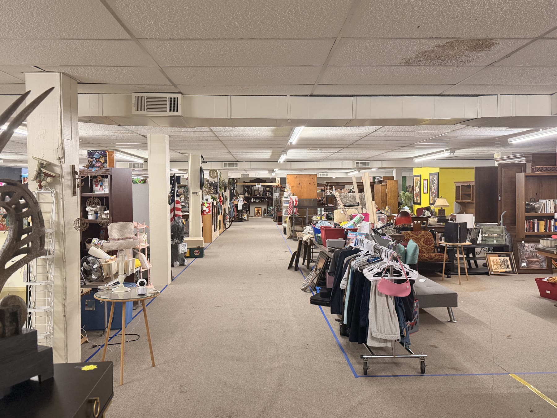 Wide marketplace aisle with vanishing-point perspective and clothing rack