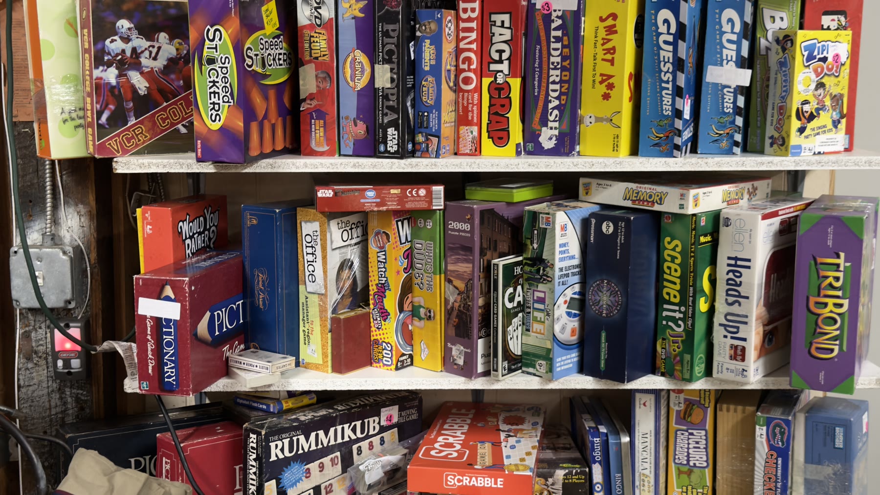 Shelves of vintage board games including Scrabble Pictionary Stratego