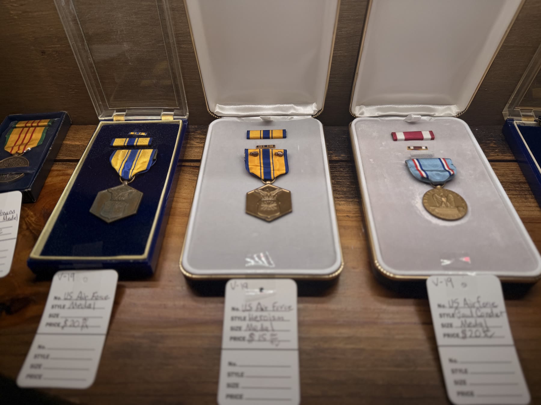 US Air Force military medals in display cases with handwritten price tags